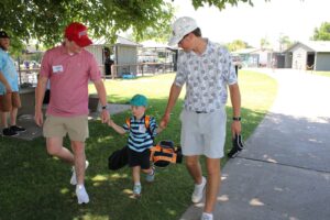 Coaches helping little golfer